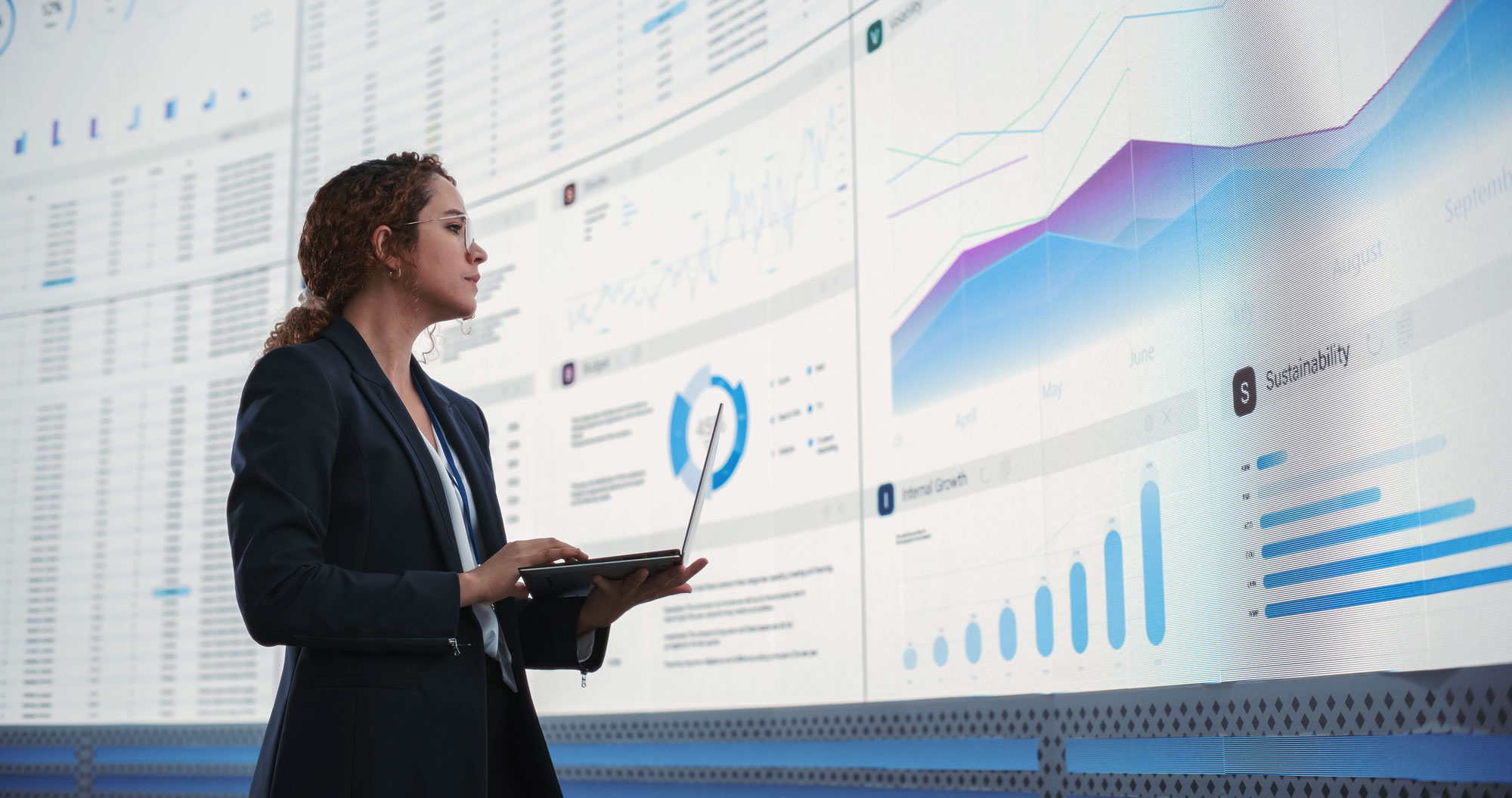 Woman viewing large monitors of information